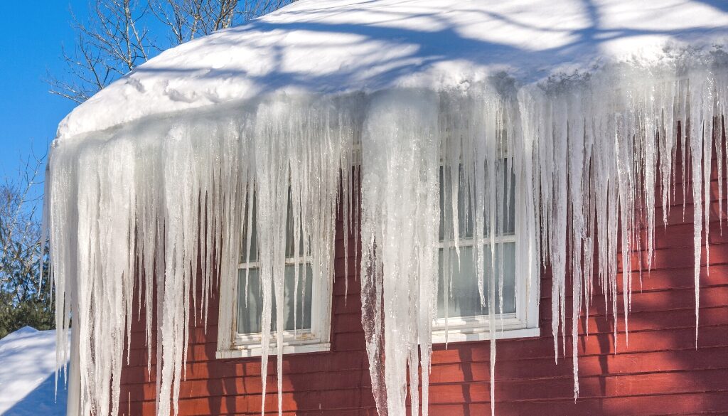 A red home with major ice dams on the roof.