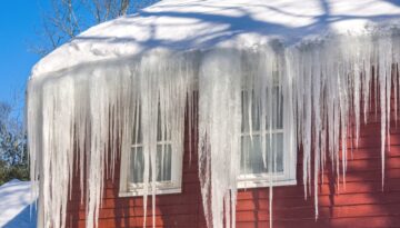 A red home with major ice dams on the roof.