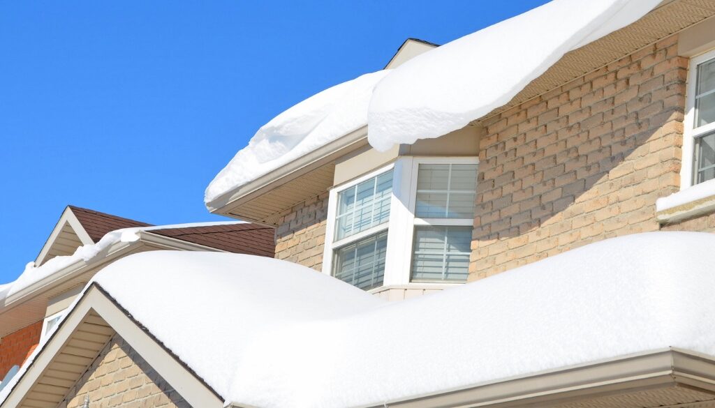 A home with an large amount of snow that needs removing.