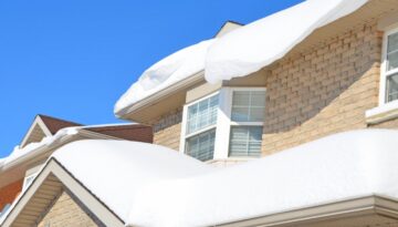 A home with an large amount of snow that needs removing.