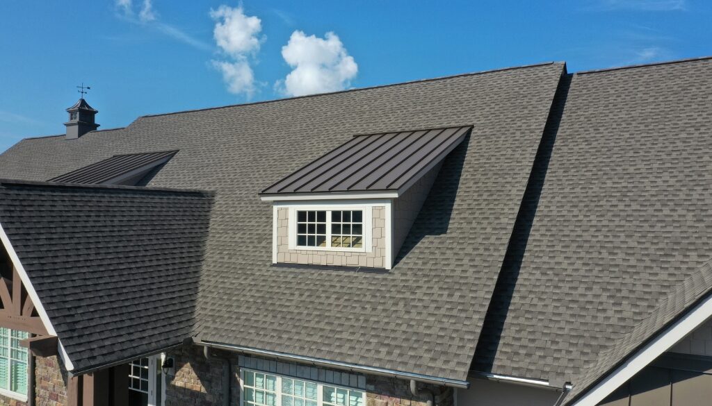 A newly installed residential roof with singles and metal.