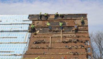 Ledegar Roofing Installers removing shingles from a commercial building in Tomah.