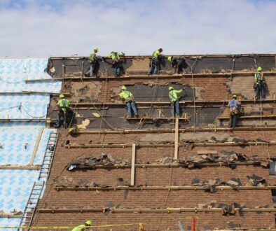 Ledegar Roofing Installers removing shingles from a commercial building in Tomah.