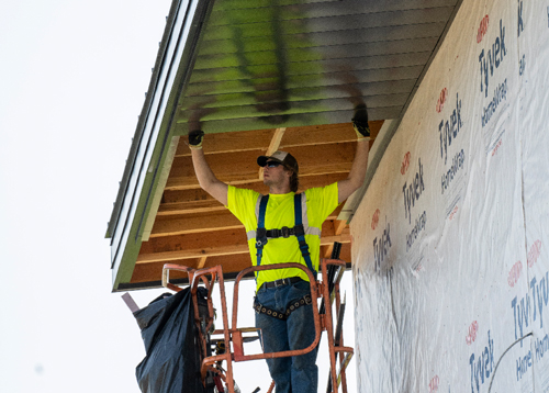 A Ledegar Roofing employee installing brand new soffit on a newly built residential home.