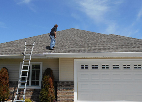 A Ledegar Roofing employee inspecting a residential home roof.