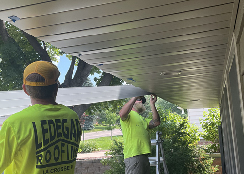 A couple Ledegar Roofing employees installing a new fascia on a residential home.