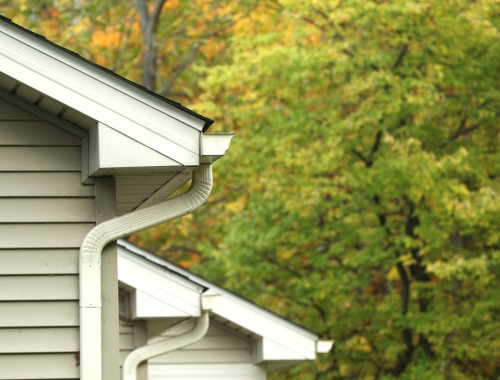 A residential home installed with white downspout system.