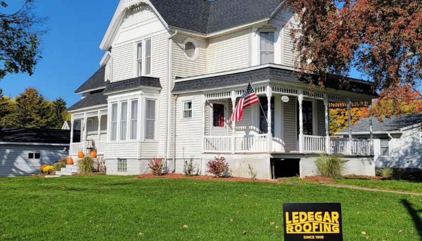 Ledegar Roofing sign posted in front of a Victorian home in West Salem, Wisconsin with a new roof.