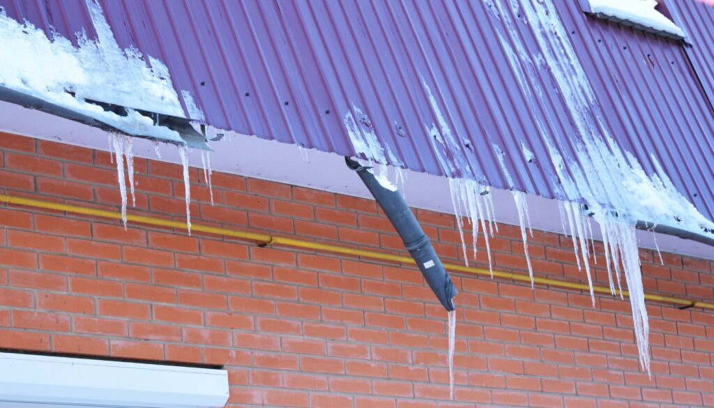 Broken gutters covered in ice and snow from the harsh winters of La Crosse, Wisconsin.