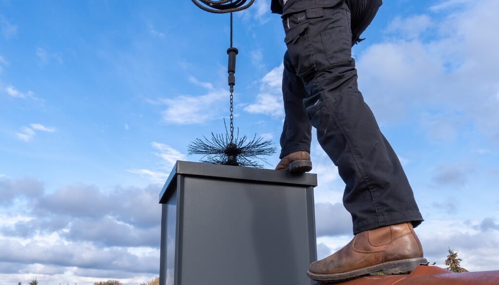 A Ledegar Roofing expert performing a chimney sweep.