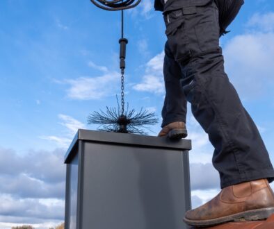 A Ledegar Roofing expert performing a chimney sweep.