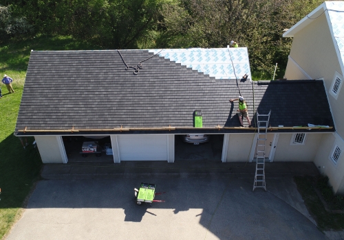 Ledegar Roofing crew members adding shingles to a residential roof. 