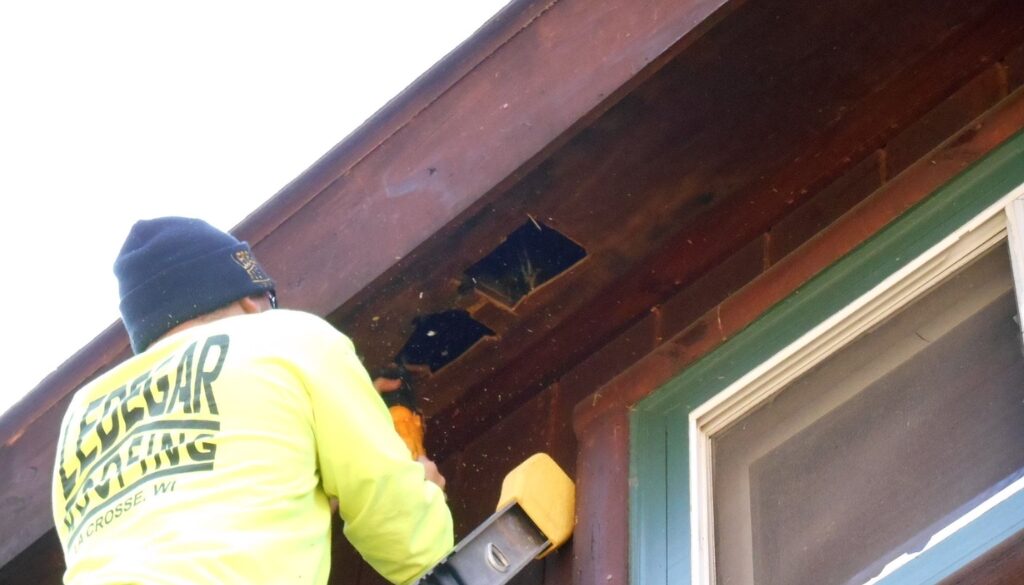 A Ledegar Roofing employee repairing damaged soffit of a residential home.