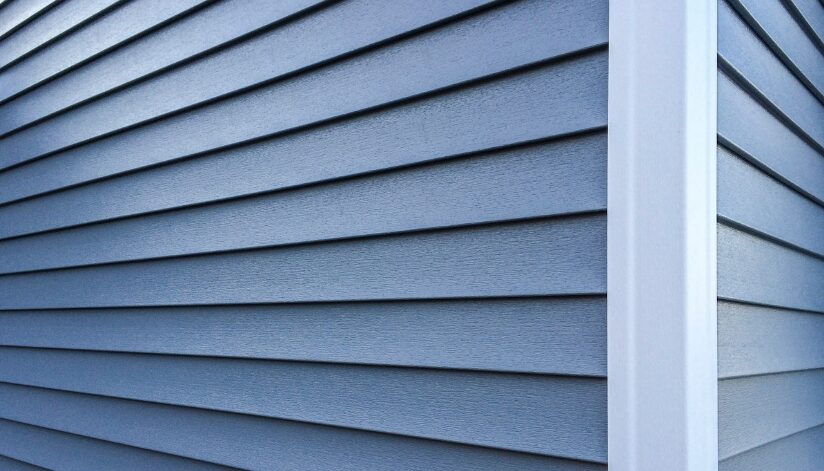 Close-up of the corner of a house with blue siding.